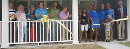 Individuals standing at a ribbon cutting