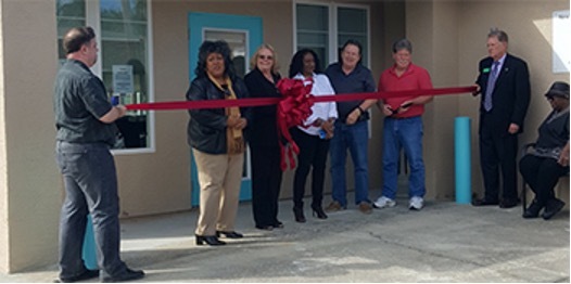 Individuals getting ready to do a ribbon cutting