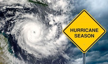 A Hurricane Season sign in front of a hurricane in the ocean. 
