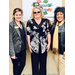 A group of three women posing in front of the Resource Center sign. 