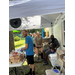  local man in a blue shirt putting hot dogs in hot dog buns 