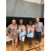  Executive Director Teresa Pope standing with three others, two of which are holding signs honoring the late Tim Hankerson 